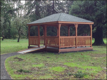 12 x 16 Cedar Rectangular Gazebo shown with Gray Composite Deck. 1x3 Railings, 36" High Railings, Standard Posts, Standard Braces, No Top Railing Section, Straight fascia, No Cupola, Cedar Tongue and Groove Ceiling, Rustic Evergreen Asphalt Shingles, Cedar Stain/Sealer, Stainless Steel Hardware, 4x4 Runners, and Hidden Wiring w/ 1 Receptacle and Switch.