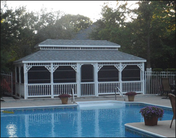 12 x 24 Vinyl Rectangular Double Roof Gazebo shown with no deck, 2x2 decorative spindle rails, decorative posts, decorative braces, straight fascia, no cupola, 4 track window system with screens, cedar tongue and groove ceiling, Old English Pewter asphalt shingles, Oil Rubbed Bronze Nedmac Outdoor Ceiling Fan w/ Pecan Palm Leaf Blades, stainless steel hardware, Hidden Wiring w/ 1 Receptacle & Switch, and extra receptacle. 