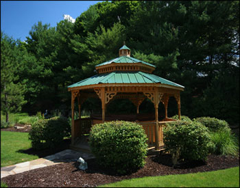 14 Treated Pine Double Roof Octagon Hot Tub Gazebo shown with Treated Pine Deck, 1x3 Railings, Decorative Posts, Decorative Braces, Cedar Stain Sealer, Stainless Steel Hardware, Sealed Base, and Evergreen Metal Roof.  Customer Installed Hot Tub. 