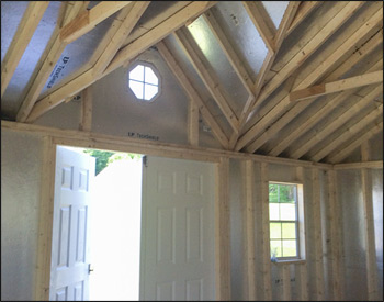 Interior - Slate Blue Vinyl Chalet Shed shown with Charcoal Metal Roof, 2 18" X 36" Vertical Sliding Windows on Each Side of the Door, a Pair of Aluminum Gable Vents, a 3 Steel Slab 9 Lite Door, 6 Vinyl Sided Double Door, 2 Pairs of Shutters, 2 Flower Boxes, and an Octagon Window Above the Door.