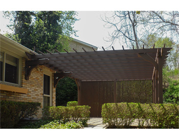 16 x 16 Cedar 2-Beam Pergola shown with Cabin Brown Stain, 12" Top Runner Spacing, Solid Wall, and No Deck. 