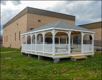 16 x 24 Vinyl Rectangular Gazebo shown with Standard White Vinyl, Treated Pine deck, 1x1 Standard Railings, Standard Braces, Straight Fascia, 4x4 Runners, Additional Entrance,and Old English Pewter Asphalt Shingles. 