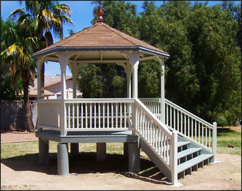 Custom 10 Treated Pine Hexagon Gazebo shown with treated pine floor, no top railings, 2x2 square railings, 5 bench sections, no cupola, copper finial, rustic cedar asphalt shingles, customer supplied stain and steps. 