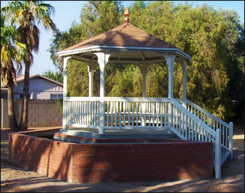 Custom 10 Treated Pine Hexagon Gazebo shown with treated pine floor, no top railings, 2x2 square railings, 5 bench sections, no cupola, copper finial, rustic cedar asphalt shingles, customer supplied stain and steps. 