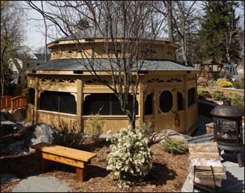 Custom 30 Treated Pine Dodecagon Double Roof Gazebo Shown with 9 Tall Posts, 36" High Solid Bottom Railing, Solid Top Rail, Standard Braces, 4 Track Window System with Screens, Screened Floor, Black Plexiglas at Double Roof, Grey Composite Decking, No Cupola, and Oxford Grey Asphalt Shingles.