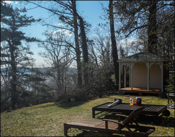 Custom 8 x 10 Treated Pine Gazebo shown with Treated Pine Deck, No Railings, No Cupola, Navajo White Stain, Hidden Wiring and Receptacle, One Solid 8 Wall and One Solid 10 Wall,